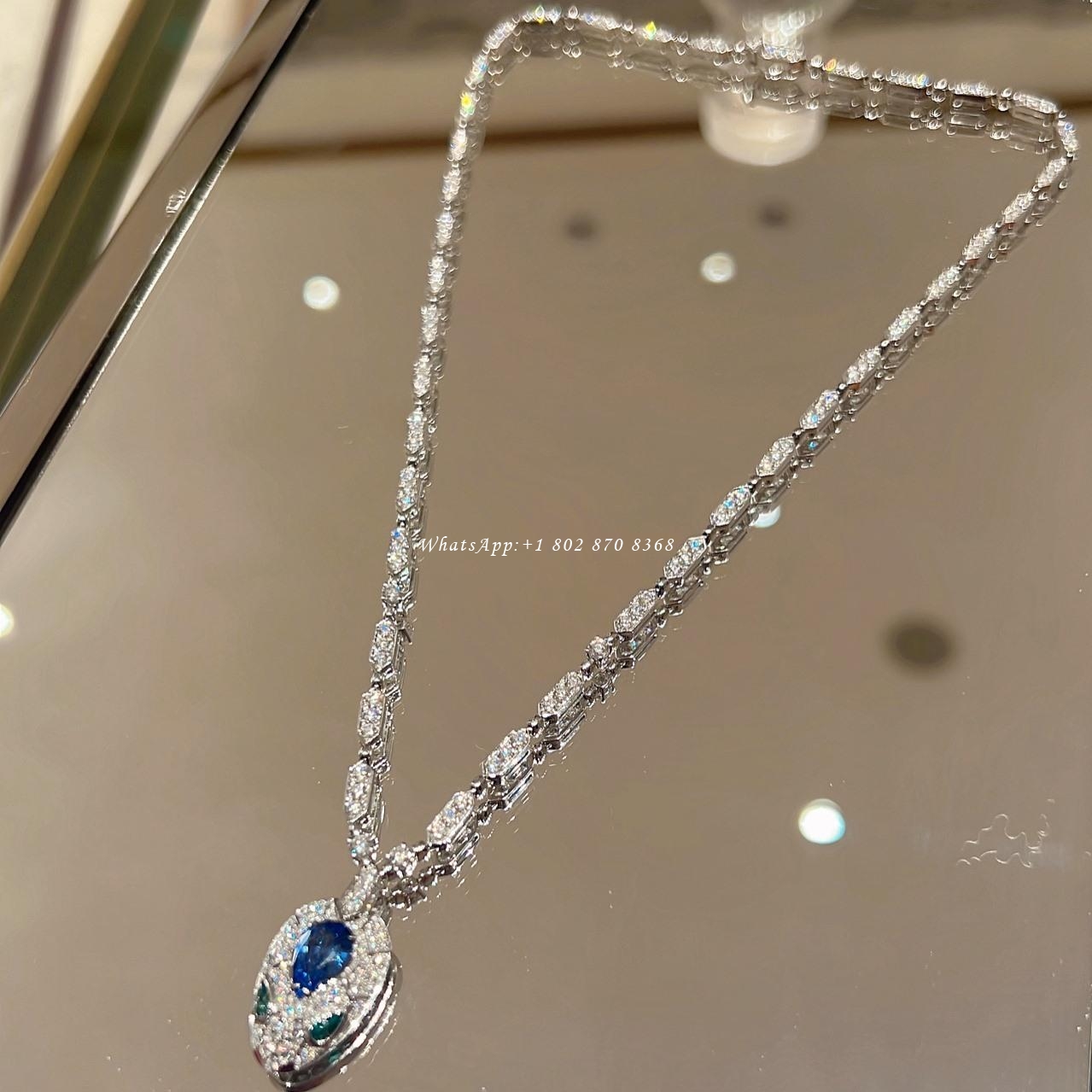 Bulgari Serpenti 18 kt white gold necklace set with a blue sapphire on the head, emerald eyes and pavé diamonds Ref. 355354